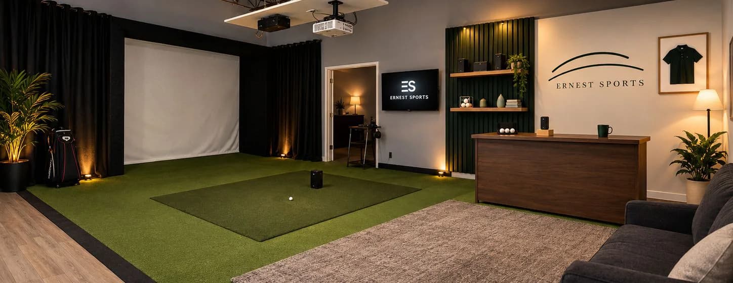 The Ernest Sports studio in Peachtree Corners: a full simulator bay with hitting mat and impact screen, product shelves, and a demo desk