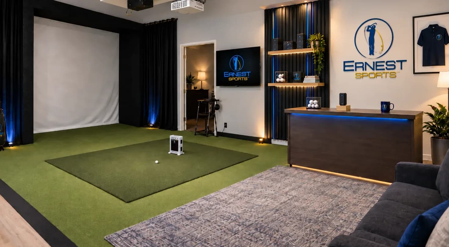 The Ernest Sports studio: simulator bay with hitting mat and impact screen, product wall, and demo desk under the Ernest Sports sign